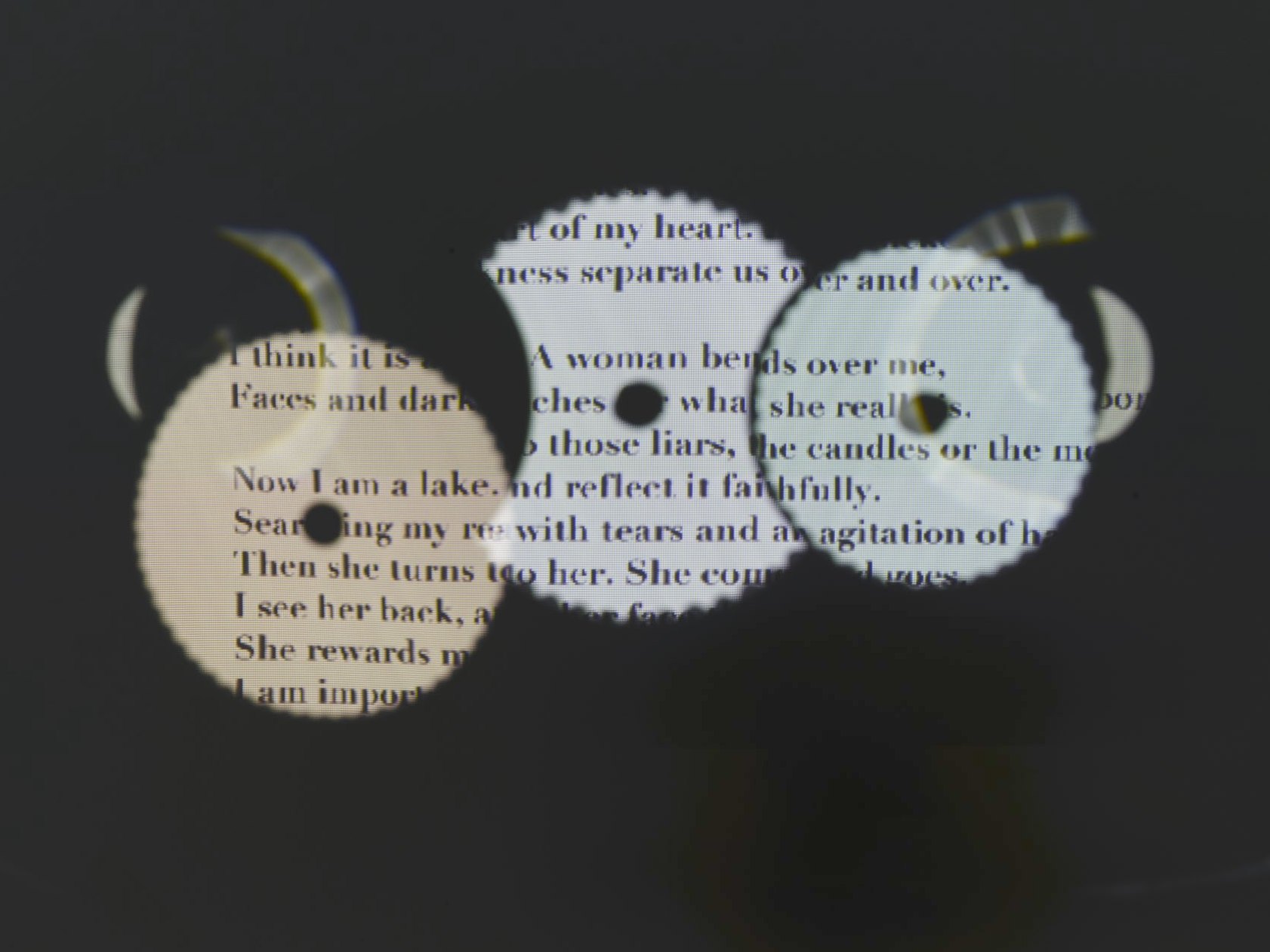 Trois disques de scie en miroir crénelés ; les vers du poème s’y lisent par fragments